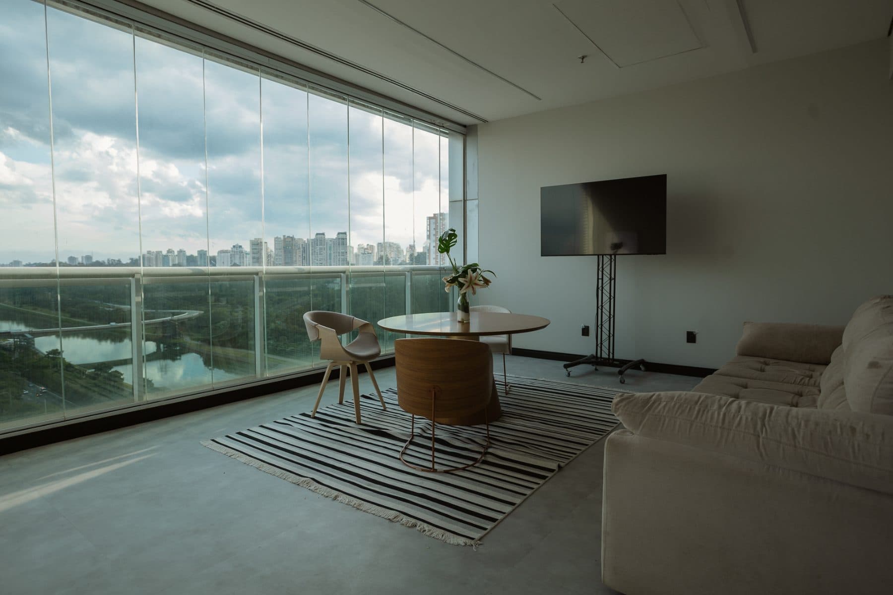 Lounge do Sales Village com smart TV e vista para o parque